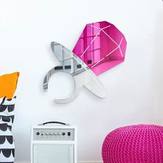 there is a purple object on the wall next to a pink chair and white table