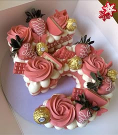 a pink and white cake in a box with gold decorations on it's edges