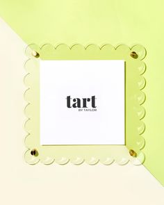 a white square frame with the word tart in black on it and scalloped edges