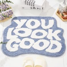 a pair of slippers sitting on top of a blue rug that says you look good