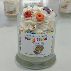 a candle that is sitting on a table next to other candles and containers filled with candy