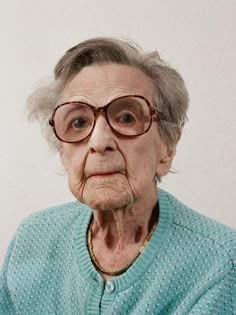 an old woman wearing glasses looking at the camera