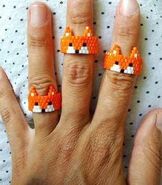 a person wearing two rings with an orange fox on them