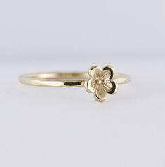 This listing includes one solid gold skinny rings with a 7mm wide flower blossom. The 1.3mm ring is made with 14K solid yellow gold, not plated or filled. Ring band: You can choose the finish on the ring band. The band shown with the flower blossom has a hammered finish. Please see the last ring picture for finish options and the description below. The photo shows white, yellow and rose gold bands but this listing includes yellow gold. From left to right in the photo: faceted, faceted, smooth, t Tiny Flower Shaped Wedding Ring, Delicate Gold Flower Stackable Rings, Delicate Flower Stackable Rings For Anniversary, Delicate Stackable Yellow Gold Flower Ring, Dainty Gold Flower Stackable Rings, Delicate Yellow Gold Stackable Flower Ring, Delicate Flower Shaped Stackable Wedding Rings, Delicate Flower Stackable Rings For Wedding, Delicate Flower-shaped Stackable Wedding Rings