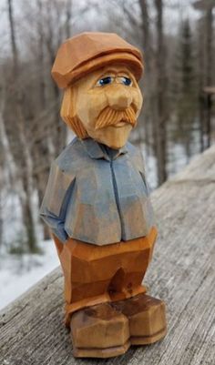 a wooden carving of a man with a hat and coat