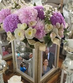 a table topped with pictures and vases filled with flowers on top of each other