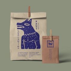 a paper bag with a blue dog on it next to a brown and white shopping bag