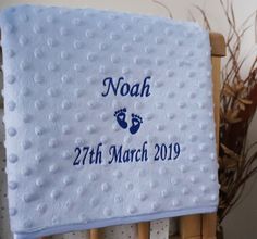 a baby's birth blanket with the words noah and feet printed on it in blue