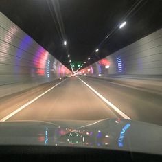 a car driving through a tunnel with lights on it's side and the view from inside