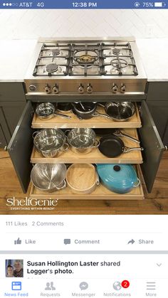 an open drawer with pots and pans in it on the side of a stove