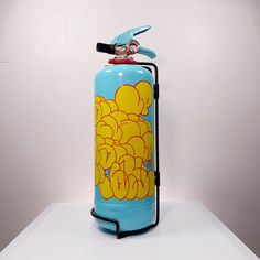 a blue and yellow fire extinguisher sitting on top of a white table