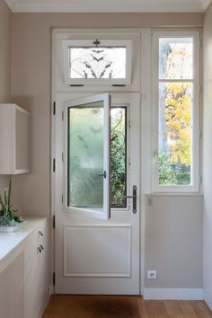 a white front door with two windows and a window sill on the side wall