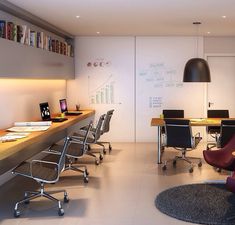 an office with desks and chairs in the middle, along with bookshelves