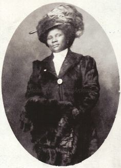 an old black and white photo of a woman wearing a fur coat with a hat on her head