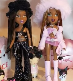 two dolls standing next to each other in front of stuffed animals and teddy bear toys