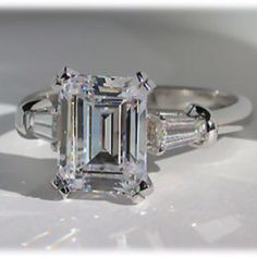 an emerald cut diamond ring with three baguets