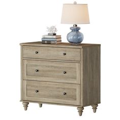 a dresser with two drawers and a lamp on top