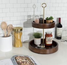 a pizza sitting on top of a wooden tray next to a bottle of wine and utensils