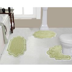 a bathroom with a toilet and rugs in it