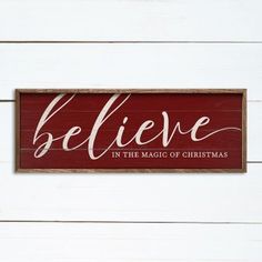 a wooden sign that says believe in the magic of christmas on white wood planks