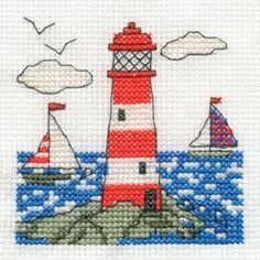 a cross stitch pattern with a lighthouse and sailboats