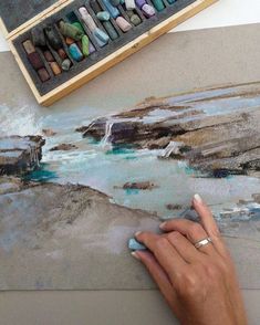 a person is painting rocks with colored pencils