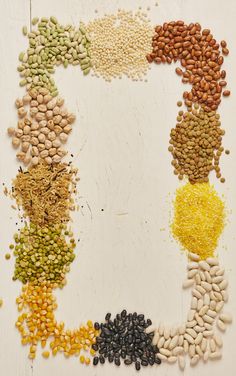 beans and lentils arranged in the shape of a letter o on a white surface