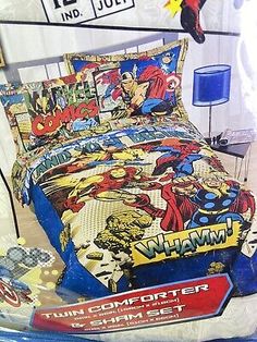 the comforter is on display in front of a bed with comic covers and pillows