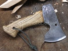 a knife is laying on top of a piece of wood next to a sawtooth