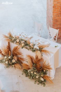 an image of a table setting with flowers and feathers