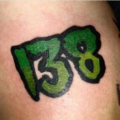 a close up of a person's arm with a green and black tattoo on it