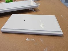 two white boxes sitting on top of a table next to each other with holes in them