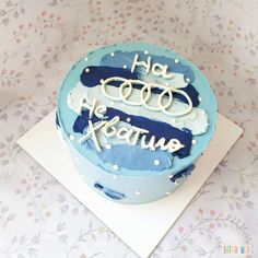 a blue cake with white frosting and writing on it