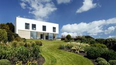 a white house sitting on top of a lush green field