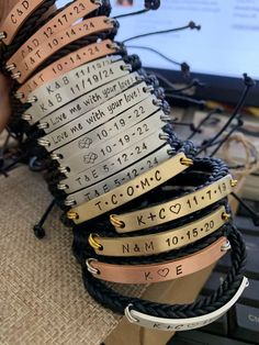 a stack of bracelets with names and date engraved on them sitting on top of a computer keyboard