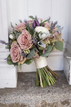 a bouquet of flowers sitting on top of a floor next to a white wall and door