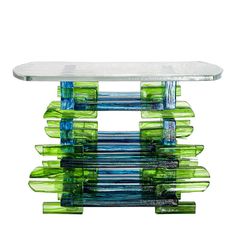 a glass table with green and blue strips on it's sides, against a white background