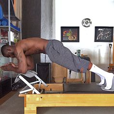 a man is doing an exercise on a desk in the living room with his feet up