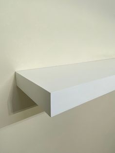 a white shelf sitting on top of a wall