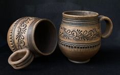 two brown vases sitting next to each other on a black tablecloth covered surface