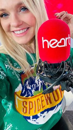 a woman holding up a microphone with the word heart on it