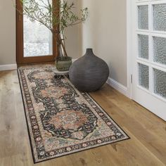 a large vase sitting on top of a wooden floor next to a door and window