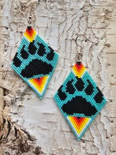 two square beaded earrings with paw prints on them