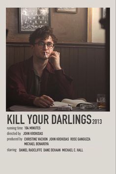 a man sitting at a table with a book in front of him and the words kill your darlings 2013 written on it