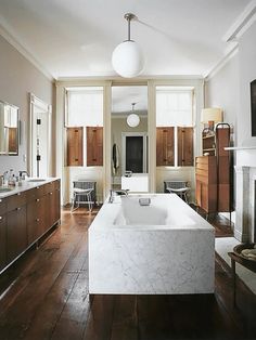 a large white bath tub sitting inside of a bathroom next to a fire place oven