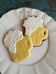 two decorated cookies sitting on top of a white plate