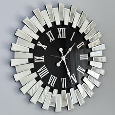 a black and white clock with roman numerals on it's face is shown