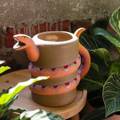 Watering your plants just got more fun with our coiled snake watering can! Pretty shades of pink and orange wrapped around a bisque clay backdrop with etched details. Water your favorite plants from the mouth of this beautiful ceramic snake. Dimensions: 7.75 x 5.0 x 6.0 inches Ceramic Snake, Reptile Crafts, Pretty Shades Of Pink, Coiled Snake, Colorful Planters, Coil Pots, Wood Fuel, Garden Stand, Pink Wrap