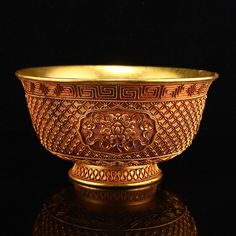 a golden bowl sitting on top of a table