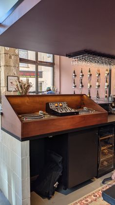 an empty bar with lots of wine glasses hanging from the ceiling